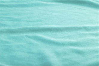 Fragment of smooth silk blue tissue. Side view, natural textile background and texture