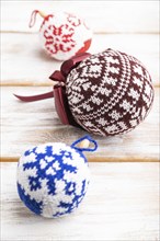 Christmas or New Year composition. Decorations, knitted balls, on a white wooden background. Side