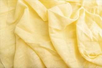 Fragment of yellow linen tissue. Top view, flat lay, natural textile background and texture. wave