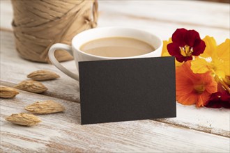 Black paper business card mockup with orange nasturtium flower and cup of coffee on white wooden