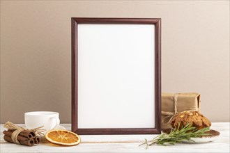 Brown wooden frame mockup with cup of coffee and cake on brown background. Blank, side view, still