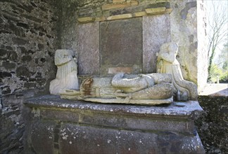 Weathered damaged memorials inside seventeenth century Kilcredan church ruins and graveyard, County