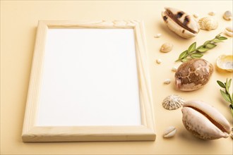 Composition with wooden frame, seashells, green boxwood. mockup on orange background. Blank, side