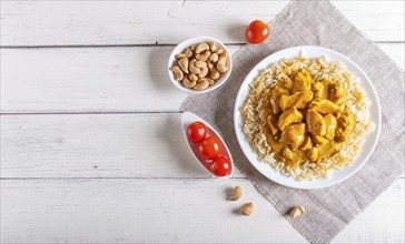 Rice with chicken curry sauce with cashew on white wooden background. top view, copy space