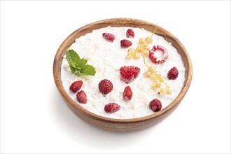 Rice flakes porridge with milk and strawberry in wooden bowl isolated on white background. Side