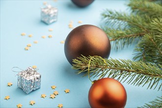 Christmas or New Year composition. Decorations, bronze balls, fir and spruce branches, on a blue