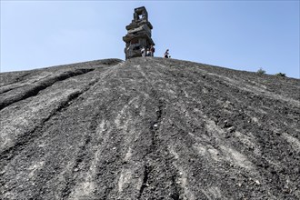 E-bikers cycle to the Rheinelbe spoil tip in Gelsenkirchen. The Himmelstreppe sculpture stands on