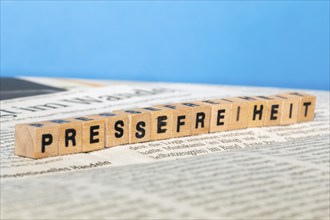 Symbolic image of press freedom: letter cube on a newspaper