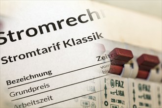 Symbolic image of electricity costs: Close-up of an electricity bill in front of a distribution box