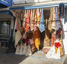 Traditional rugs hanging on display outside shop in medina area of Essaouira, Morocco, north