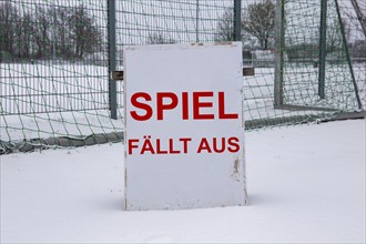 Symbolic image of a football match cancelled due to snow. Sign on a sports field with the