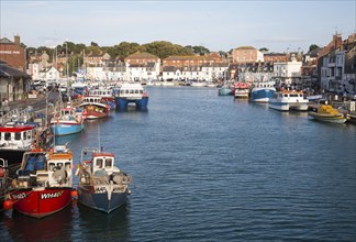 Colourful fishing boats in the harbour at Weymouth, Dorset, England, UK