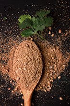 Fresh cilantro, coriander grains and powder, on a wooden table, top view, no people