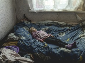 Angelina, 9 years old, on her bed. The village of Borshchivka was under Russian occupation. She has