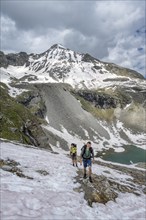 Two mountaineers on a hiking trail with snow, mountain landscape with summit Hoher Riffler and