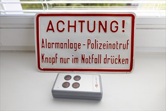 Operation of an alarm system, information sign, police emergency call button