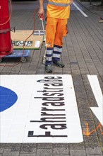 Application of road markings for a cycle lane, Rüttenscheider Straße in Essen, in the shopping and