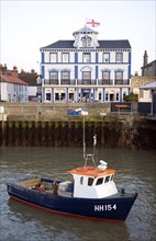 Fishing boat in harbour with Pier hotel, Harwich, Essex, England, UK