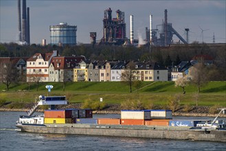 Cargo ships on the Rhine near Duisburg-Laar, houses on Deichstrasse, industrial backdrop of the