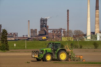 Farmer working in the field, Duisburg-Baerl, sowing, in the background the ThyssenKrupp Steel blast