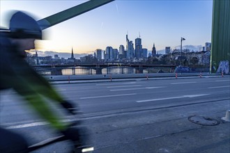 Skyline of the city centre of Frankfurt am Main, cyclist on the raft bridge, dusk, river Main,