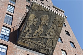 Harbour workers loading sacks of grain, historical relief on the office building Speicher Dock 13,