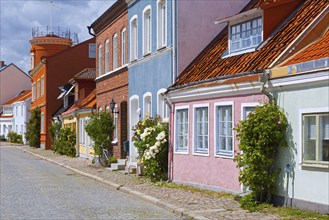 Cobbled street with colourful houses in pastel colours in the town Ystad in summer, Skåne, Scania,