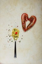 Spaghetti wrapped on a fork, langoustines heart shape, on the table, food concept, food background,