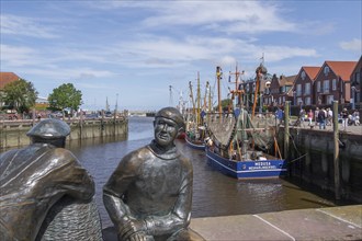 Sculpture of old and young fishermen at the cutter harbour Neuharlingersiel, East Frisia, Lower