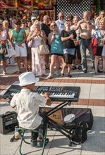 Young street musicians with happy crowd on the promenade in Swinoujscie, West Pomerania, Poland,