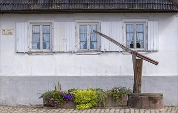 Old fountain in front of a house, Hunspach, Alsace, France, Europe