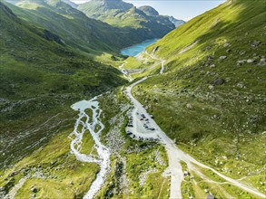 Parking lot at glacial lake Lac de Chateaupre, camper vans, lake Lac de Moiry in the back, aerial