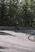 Road bike rider in spring in the Allgäu against the picturesque backdrop of the Alps, Bavaria,