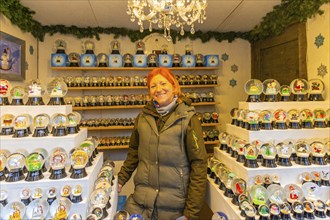 Saleswoman in a stand for snow globes at the Christmas market at St Stephen's Cathedral,