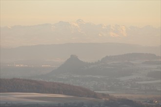 Hegaublick in winter and sunset. Hohenkrähen castle ruins with the Alps and the Säntis