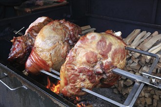 Pork knuckles are grilled on a spit over a wood fire, Prague, Czech Republic, Europe