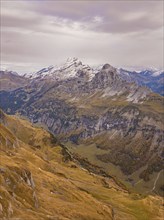 Snow-covered mountains and valleys, criss-crossed by rocky passes under a cloudy sky, Alpen Tower,