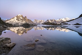 Evening mood with pink evening sky, mountain landscape at sunset, water reflection in Lac Blanc,