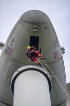 Height rescuers from the Gelsenkirchen fire brigade practise abseiling from a wind turbine from a