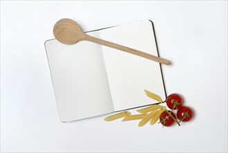 Notebook for recipes, cooking spoons, pasta and tomatoes