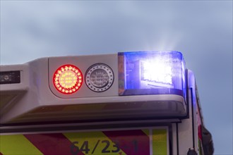 Close-up of an ambulance with flashing blue lights in the rain, Stuttgart, Baden-Württemberg