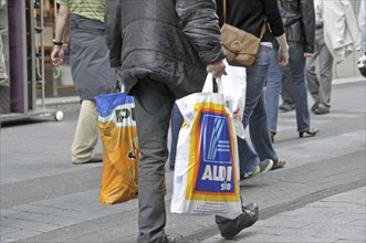 Old man after shopping at the discounters: plus and Aldi-Süd, pedestrian zone in Cologne, North