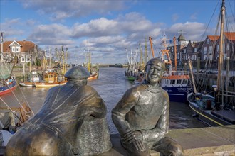 Sculpture of old and young fishermen at the cutter harbour Neuharlingersiel, East Frisia, Lower