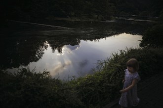 Symbolic photo on the subject of dangers on the water for small children. A little girl runs along