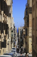 Narrow street historic housing with traditional balconies in city centre of Valletta, Malta, Europe