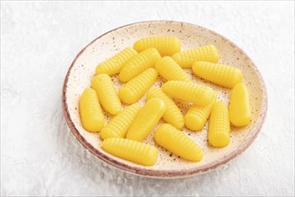 Jelly corn candies on gray concrete background. side view, flat lay, close up