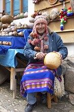 Peruvian man with traditional cap and mates burilados or engraved gourds, Chinchero, Cusco region,