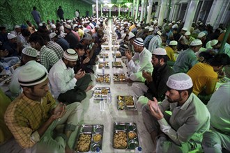 Muslim devotees offer prayers before have 'iftar' meal together to break their fast during the holy