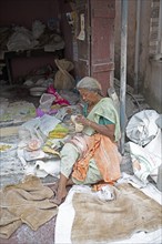 Indian woman making pappadam or Indian bread on the footpath, Kochi, Kerala, India, Asia