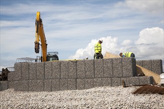 Repair work on steel mesh cages known as gabions which provide coastal defence at Chiswell, Isle of